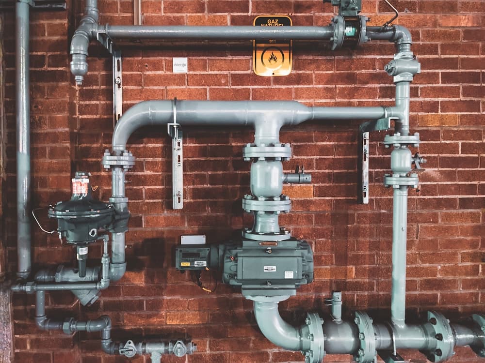 A plumber fitting pipework under a sink (illustrative)